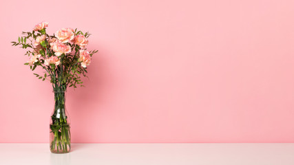 Bunch with a beautiful pink carnation flower on white table. Pastel rose background, copy space for your text