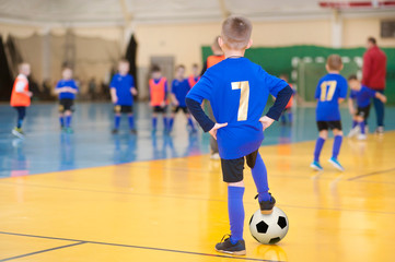 Children's football in the hall. The boy with the ball.