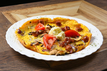 Omelet with sausages and vegetables