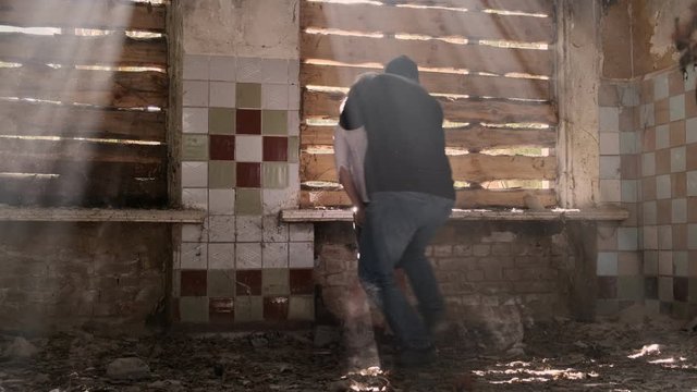 criminal holds hostage by threatening with pistol near window in abandoned building. offender is covered for victim.