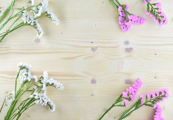 white and purple flowers on wooden background in aerial shot with copyspace