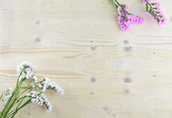 white and purple flowers on wooden background in aerial shot with copyspace