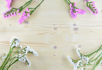 white and purple flowers on wooden background in aerial shot with copyspace