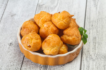 Sweet tasty profiteroles heap in the bowl