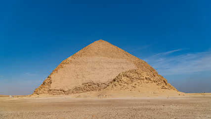 The Bent Pyramid is an ancient Egyptian pyramid located at the royal necropolis of Dahshur, approximately 40 kilometres south of Cairo, built under the Old Kingdom Pharaoh Sneferu. Egypt