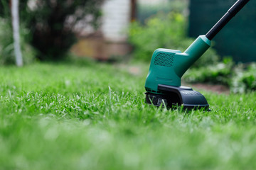 Mowing grass with electric trimmer