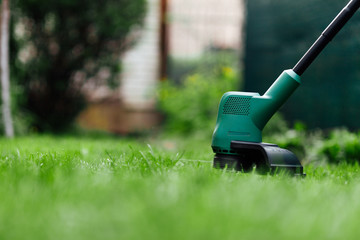 Mowing grass with electric trimmer