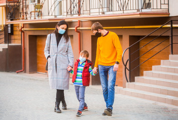 Air pollution concept. Prevention coronavirus. Parents and kid wearing a surgical mask.Coronavirus quarantine. Family going walk