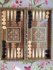 Backgammon with wooden inlay. Wooden backgammon board game of pearl inlaid on brown background.