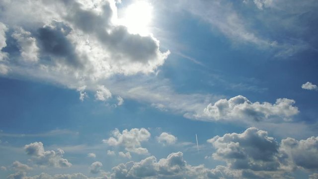 4k aerial video of blue sky with white fluffy cumulus clouds during spring, pitching down 