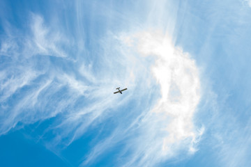 Fototapeta na wymiar Light airplane flying high in the blue sky. 