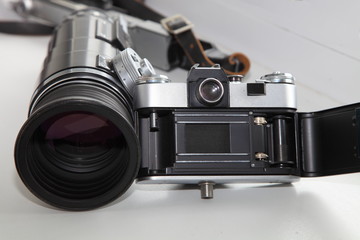 Fototapeta na wymiar Vintage photo equipment set - retro SLR camera and big diameter lens with rubber lens hood