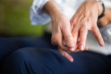 Close up older woman hands touching fingers