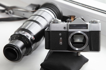 Vintage SLR film camera body with old big lens b/w contrast picture, retro photo components