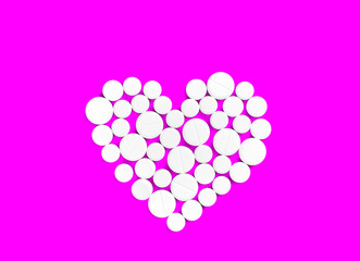 White medicine pills in the shape of a heart on a pink background top view with copy space.