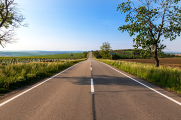 Asphalt road between the fields near the town of Karlín in the Czech Republic.