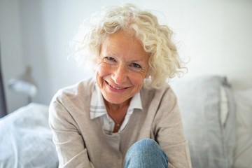 Fototapeta na wymiar Close up smiling older woman relaxing at home