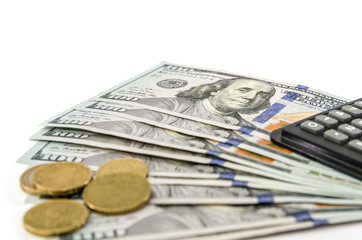 dollars with coins and calculator on white.
