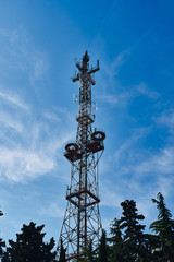 Old city television tower against the sky and trees. Old TV Tower.