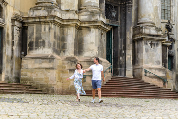 Fototapeta na wymiar Loving couple walks by the hand against the background of the old church.