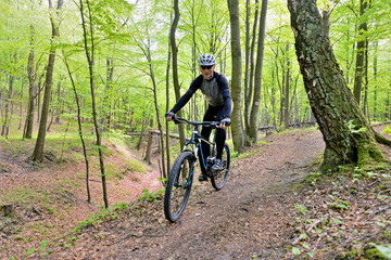 Fototapeta na wymiar A man on a bicycle riding on a forest path.