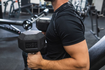 brazo musculoso de un joven entrenando en gimnasio