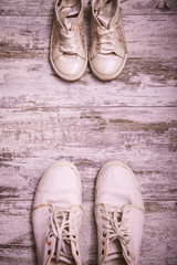 Big and small shoes on wooden background. Still life photography : father and child shoes on old wood in vintage color tone, go ahead together and fathers day concept.