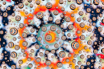 multi-colored mandala through drops of water on glass