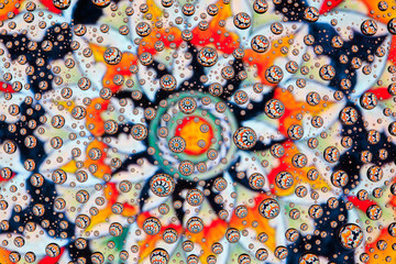 multi-colored mandala through drops of water on glass
