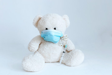 soft toy with an injection in a medical mask on a white background
