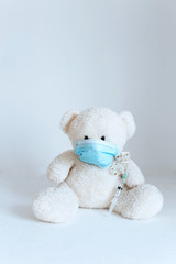 soft toy with an injection in a medical mask on a white background