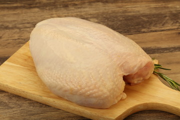 Raw whole chicken breast with skin