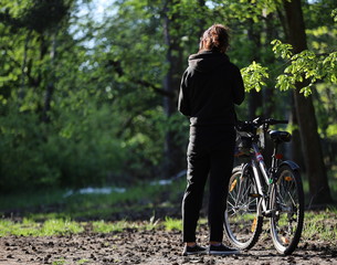 Fototapeta na wymiar young woman riding a bicycle, forest in Poland