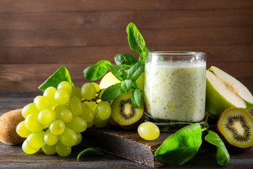 yogurt with fresh kiwi, Apple, green grapes,  spinach and mint on a wooden