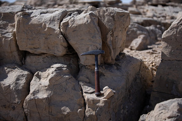 Limestones and testing hammer of geologists in limestone quarries