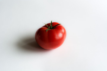 Red tomato lying on a white background
