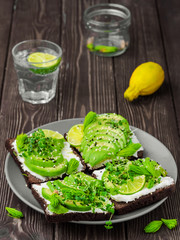 Sandwich with microgreens, cheese, avocado and spruce tips. Close-up, delicious and healthy vegetarian breakfast.