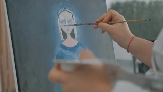 vista de cerca de mano de pintora con pincel y paleta de artista