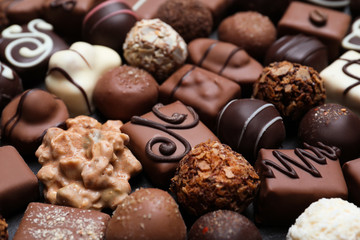 Different delicious chocolate candies as background, closeup