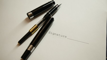 Blank ink pen without ink near the signature of the document