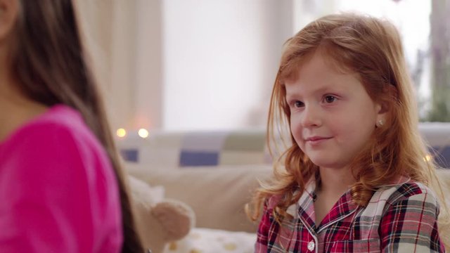 Small girl friends on kids sleepover slumber party, combing hair.