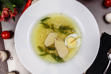 a white bowl filled with Delicious chicken noodle soup