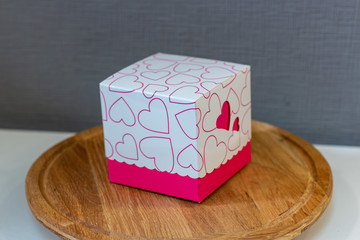 gift box with pink hearts on a wooden stand