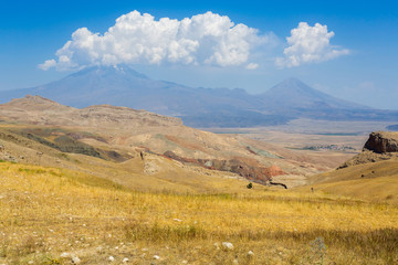 Greater Ararat and Little Ararat. Panoramic view of Mount Ararat from Turkey, Eastern Anatolia. Beautiful landscape with a massif and blue sky. Mountain peak in the clouds