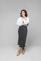 Fototapeta premium Young caucasian female with short chestnut wavy hair in black and white long summer dress and white shirt