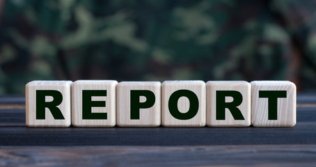 The word REPORT on cubes on a beautiful camouflage background