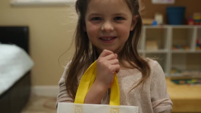 Little Girl Showing Artwork on The Antistress Coloring Bag. Happy girl is satisfied with her hand work and holding her bag.