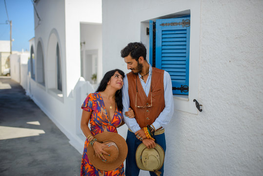 A man and a woman are posing in the streets of Imerovigli Village, on Santorini Island..He is an ethnic gypsy. She is an Israeli.