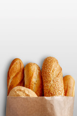 A paper bag with bread on the grey background.