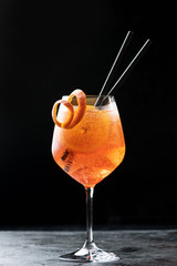 Classic italian aperitif aperol spritz cocktail in glass with ice cubes and with slice of orange on...